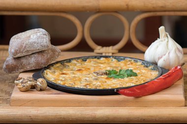 Ekşi krema ve peynirli mantarlar sarımsak ve biberle pişirildi.