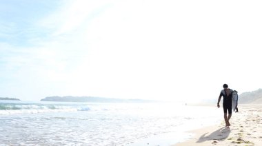 Sahilde yürüyüş sörfçü