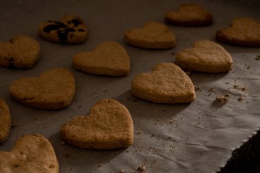 Pişirme kağıdında kalp şeklinde kurabiyeler.