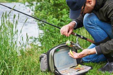 Balıkçılık ekipmanları, olta ve balık yemi kullanan adamlar.. 