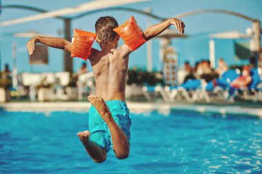 Avrupalı çocuk havuza atlarken eğleniyor.