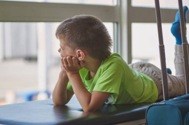 Beyaz çocuk havaalanında uçağa binmek için bekliyor..