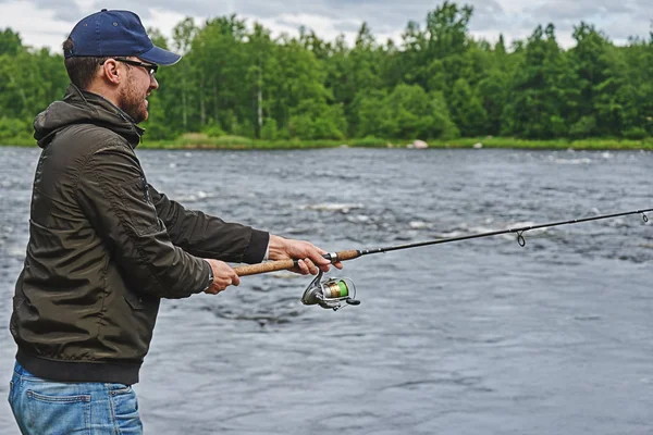 Nehirde oltayla balık tutan bir adam.