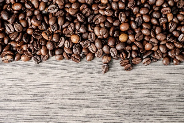 Ahşap masa arka plan üzerinde kahve çekirdekleri kavramı.