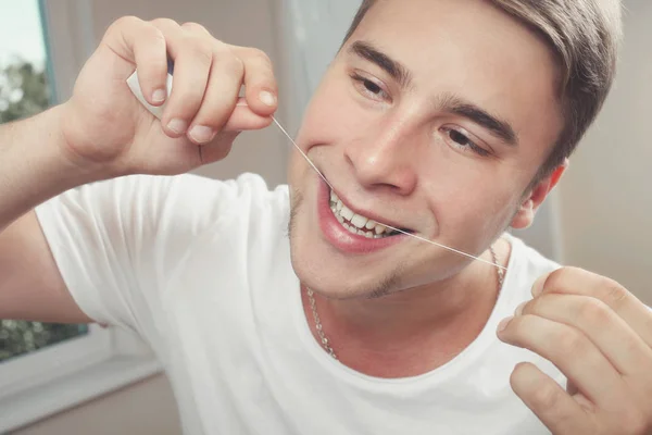 Man is brushing his teeth with a dental floss — Stock Photo, Image