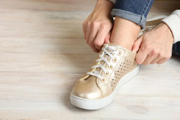 Sapatilha dourada na menina na perna — Fotografia de Stock