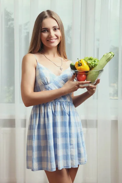 A menina está segurando uma tigela de legumes frescos — Fotografia de Stock