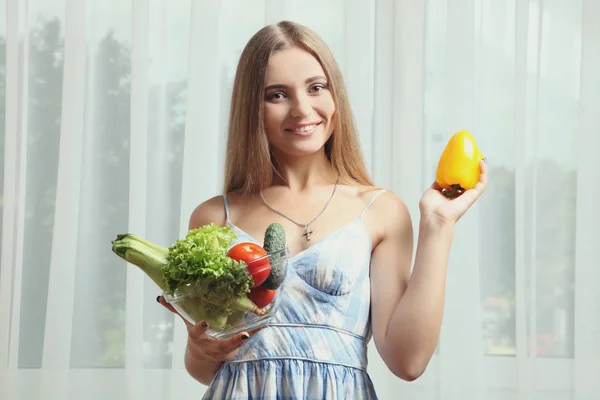 Una chica está de pie con un tazón de verduras frescas — Foto de Stock