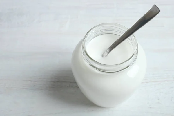 Słoik z jogurtem i łyżką — Zdjęcie stockowe