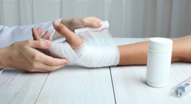 Bir hemşire bir hastanın el sargılar 