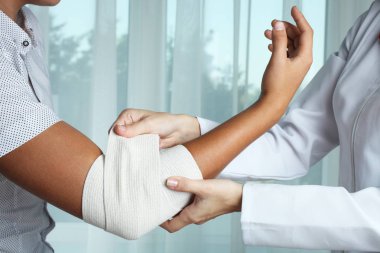 Hemşire çocuğun dirsek Elastik Bandaj ile biler