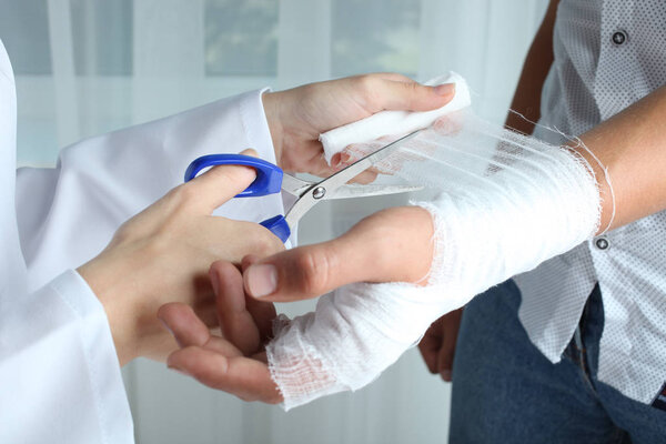 nurse cuts the bandage with scissors 
