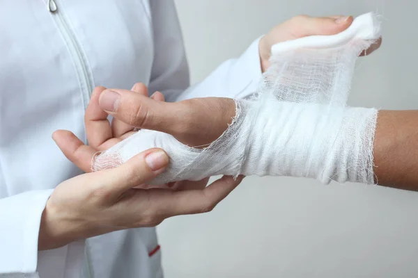 En sjuksköterska bandage en patientens hand — Stockfoto