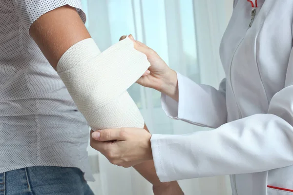 Hemşire çocuğun dirsek Elastik Bandaj ile biler