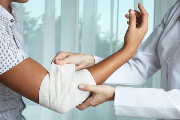 Hemşire çocuğun dirsek Elastik Bandaj ile biler