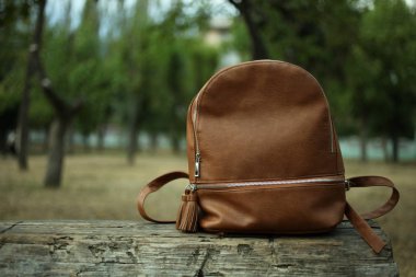  bir ahşap bank üzerinde kahverengi sırt çantası 