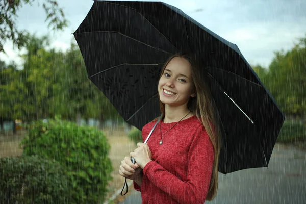 Girl is under a black umbrella — Stock Photo, Image