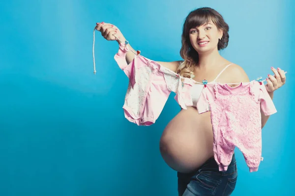 Mulher grávida com roupas infantis — Fotografia de Stock