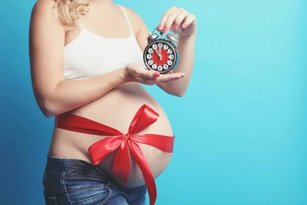 Femeie gravidă cu ceas deşteptător — Fotografie, imagine de stoc