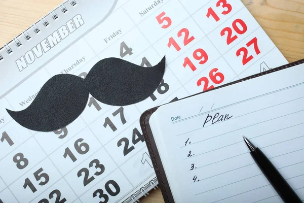 Kalender, schwarzer Schnurrbart und Notizblock — Stockfoto