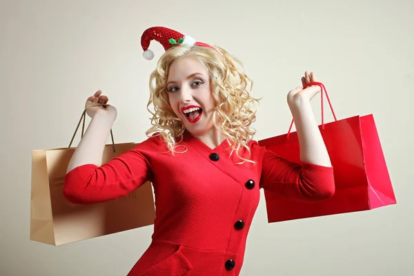 Fille dans un chapeau de Noël et des paquets — Photo