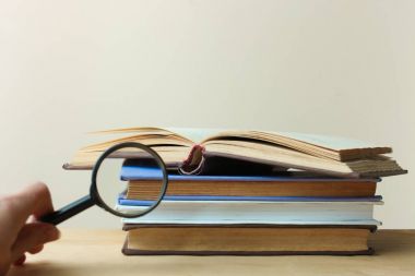 Bir yığın kitap ve Büyüteç 