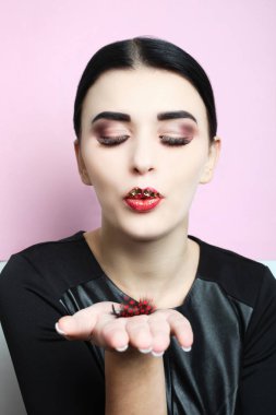 Güzel kız, güzel makyaj ve pembe bir arka plan üzerine uzatılmış kirpik ile esmer.