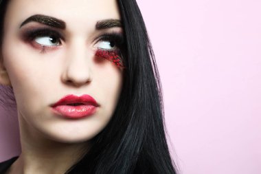 Güzel kız, güzel makyaj ve pembe bir arka plan üzerine uzatılmış kirpik ile esmer.