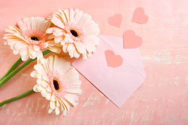 Üç güzel pembe gerbera ve pembe ahşap arka plan üzerinde romantik bir not. Kopya alanı.