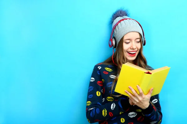 Дівчина слухає музику і тримає книгу — стокове фото