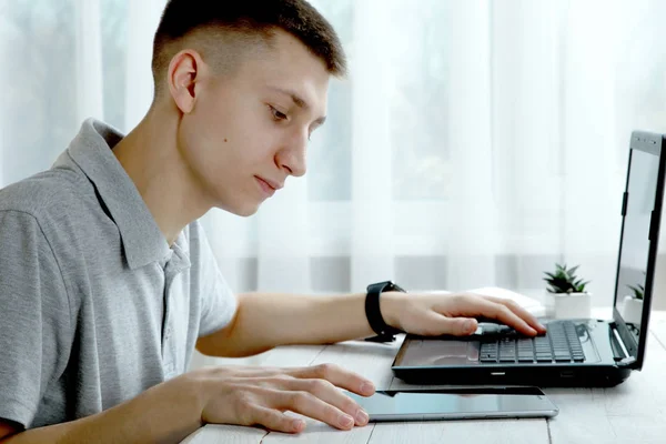 The guy works behind a laptop — Stock Photo, Image