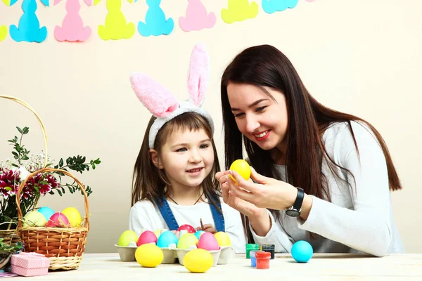 Mother and little daughter coloring Easter eggs — Stock Photo, Image