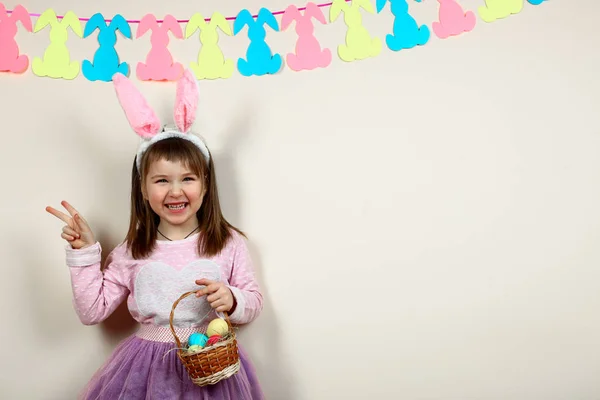 Smiling girl with a basket of Easter eggs — Stock Photo, Image