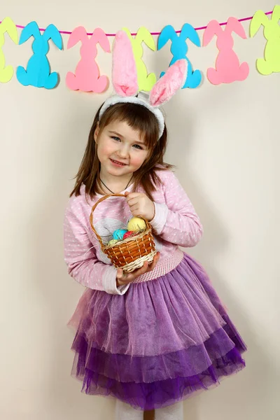 Smiling girl with a basket of Easter eggs — Stock Photo, Image