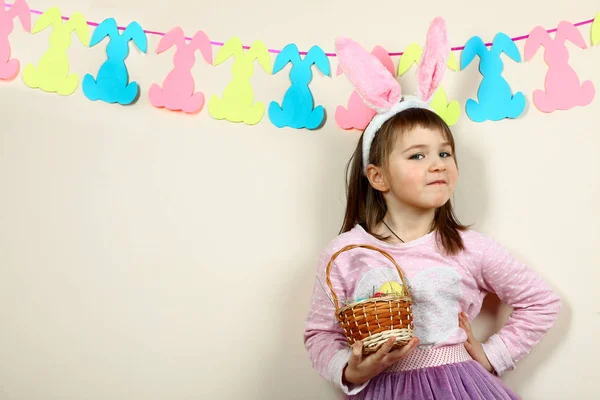 Smiling girl with a basket of Easter eggs — Stock Photo, Image