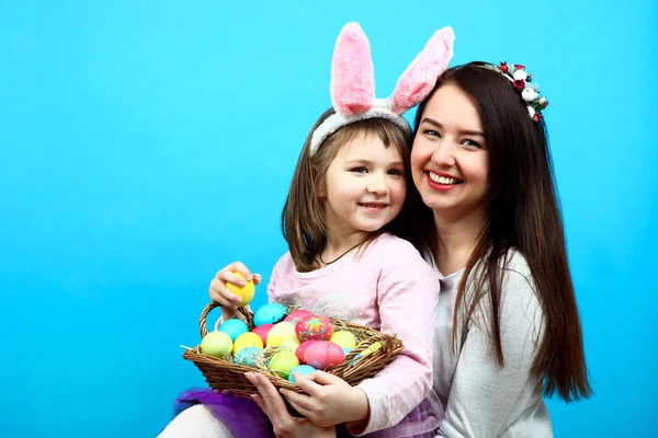 Mom and little girl with a basket of easter eggs — Stock Photo, Image