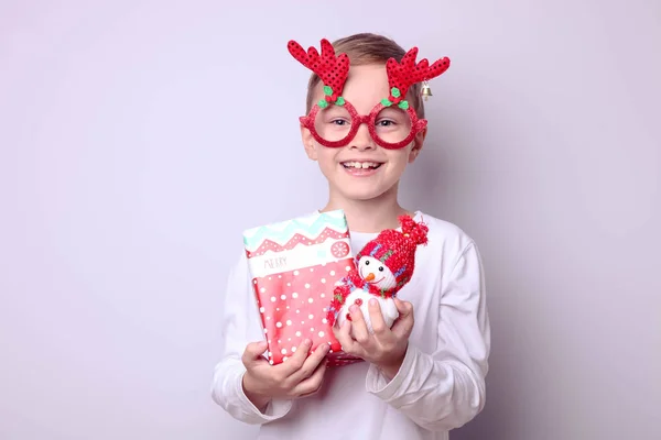 Garçon en lunettes de mascarade avec cornes de cerf avec des cadeaux — Photo