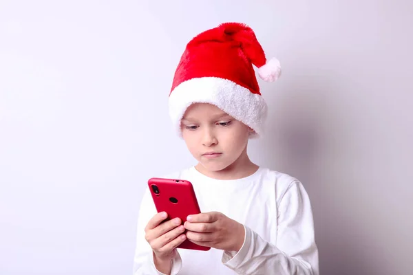 Garçon dans un chapeau de Père Noël avec un smartphone — Photo