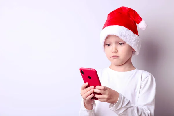 Garçon dans un chapeau de Père Noël avec un smartphone — Photo