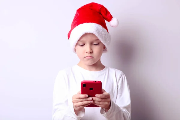 Garçon dans un chapeau de Père Noël avec un smartphone — Photo