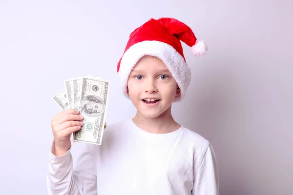 Garçon dans un chapeau de Père Noël avec des dollars — Photo