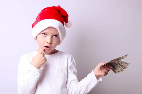 Garçon dans un chapeau de Père Noël avec des dollars — Photo