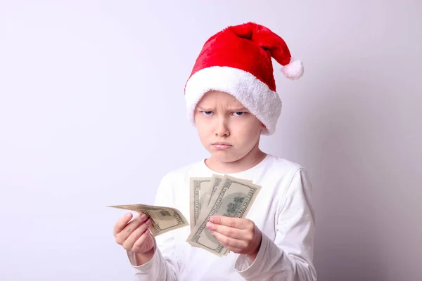 Garçon dans un chapeau de Père Noël avec des dollars — Photo