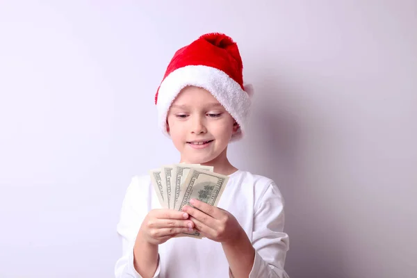 Garçon dans un chapeau de Père Noël avec des dollars — Photo