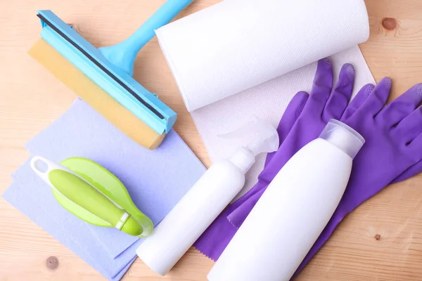 Different cleaning products on wooden background.