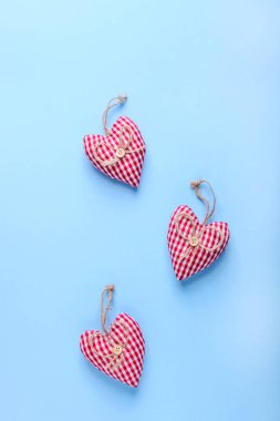 Mavi arka planda kumaştan yapılmış kırmızı kalpler. Sevgililer Günü konsepti.