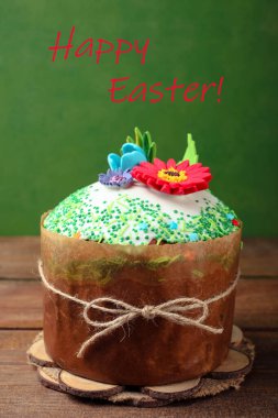 Yeşil arka planda çiçeklerle süslenmiş Paskalya pastası..
