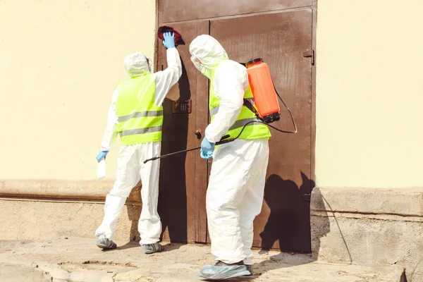 Specjaliści Kombinezonów Ochronnych Dezynfekują Wejście Domu Kontrola Epidemii — Zdjęcie stockowe