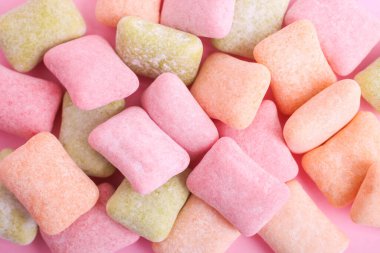 Pembe arka planda çok renkli sakız yastıkları.