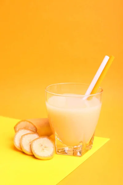 Sok Bananowy Szklance Plasterkami Bananów Żółto Pomarańczowym Tle Letni Drink — Zdjęcie stockowe
